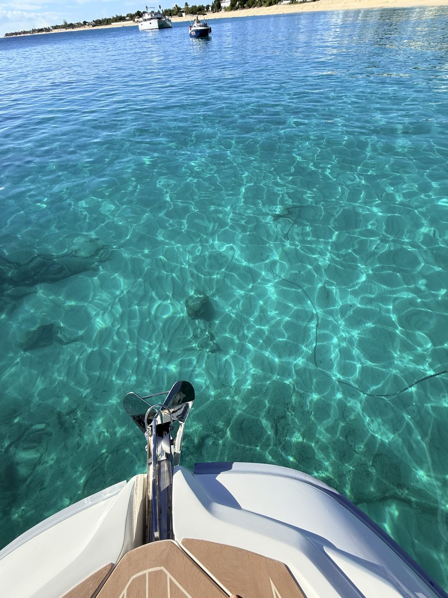 L'eau transparente sur le sable, vue depuis l'avant du semi-rigide au mouillage à La Samanna